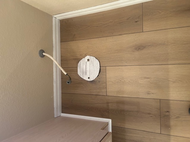 Close-up of warm oak wood-look flooring with a recessed floor outlet in a Las Vegas home