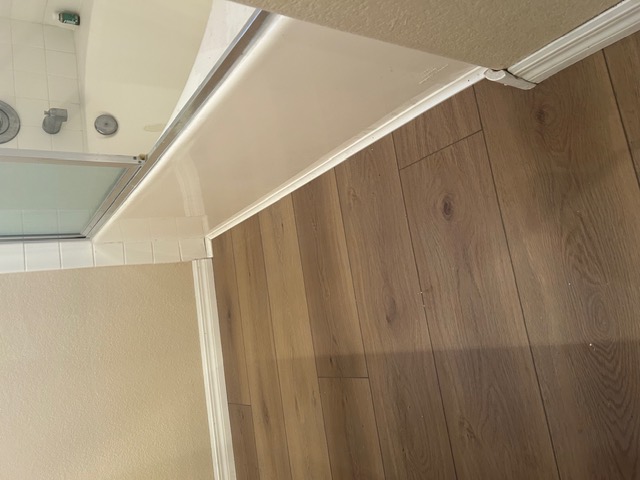 Warm oak wood-look flooring beside a bathtub in a Las Vegas bathroom