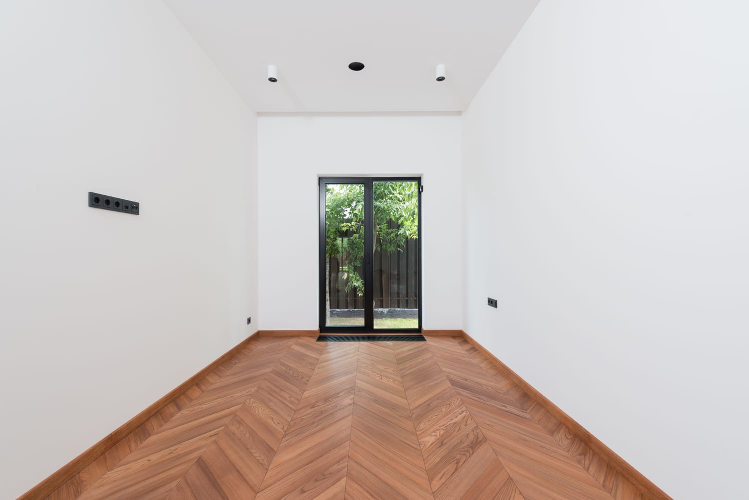 Herringbone wood flooring in a bright Las Vegas room with French doors