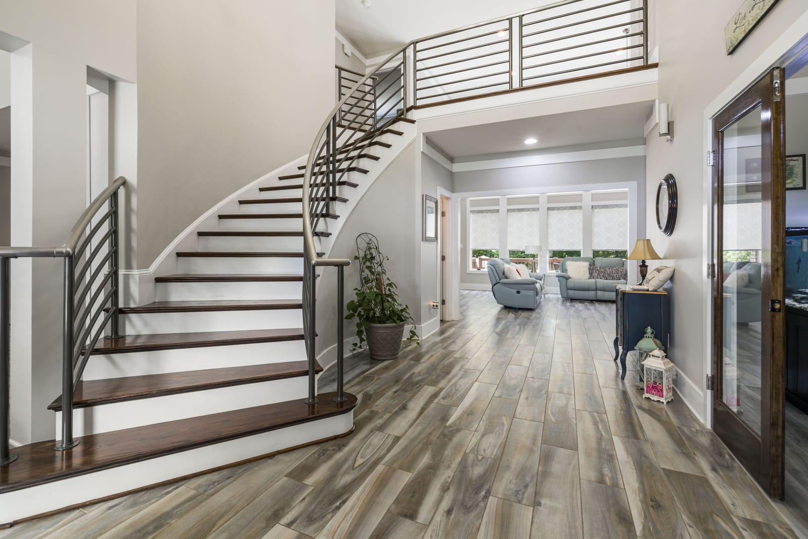 Curved modern staircase with gray wood-look flooring in a Las Vegas home