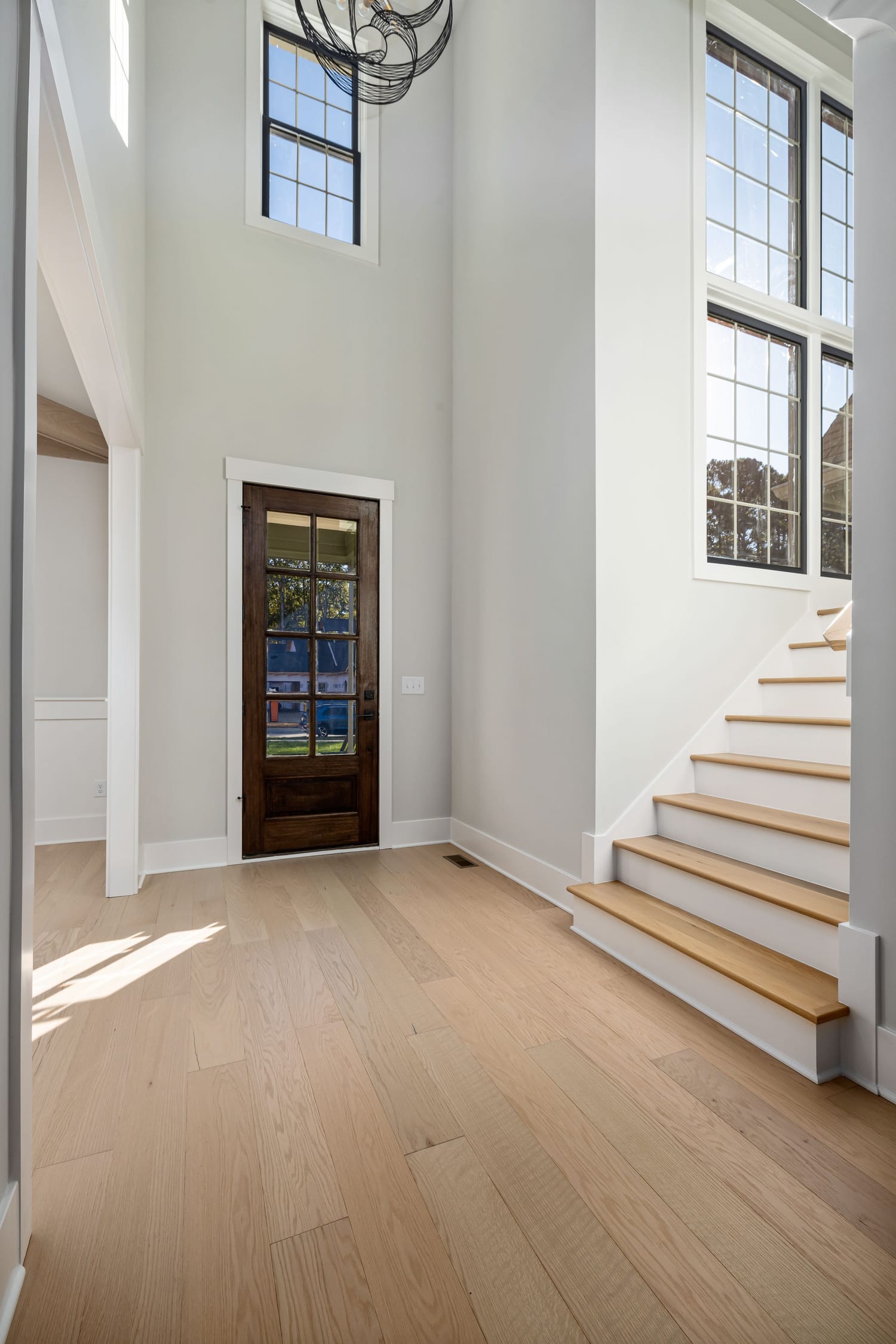White oak staircase and flooring in a bright two-story Las Vegas foyer