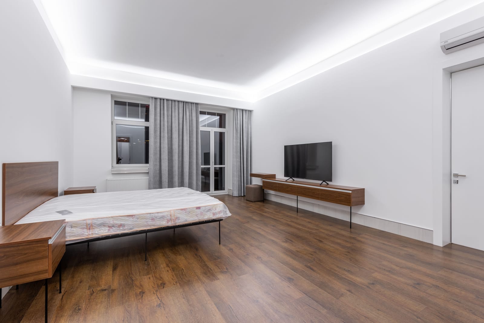 Dark walnut wood flooring in a spacious Las Vegas bedroom